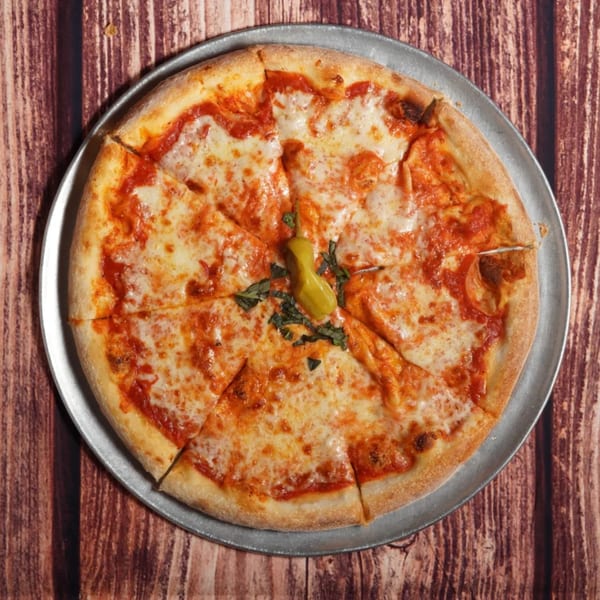 A Billito's Italian Restaurant cheese pizza, sliced, with a pepperoncini and basil on a metal pan.
