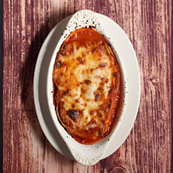 Billito's Italian Restaurant's baked lasagna, topped with melted cheese and rich tomato sauce, in a white dish.